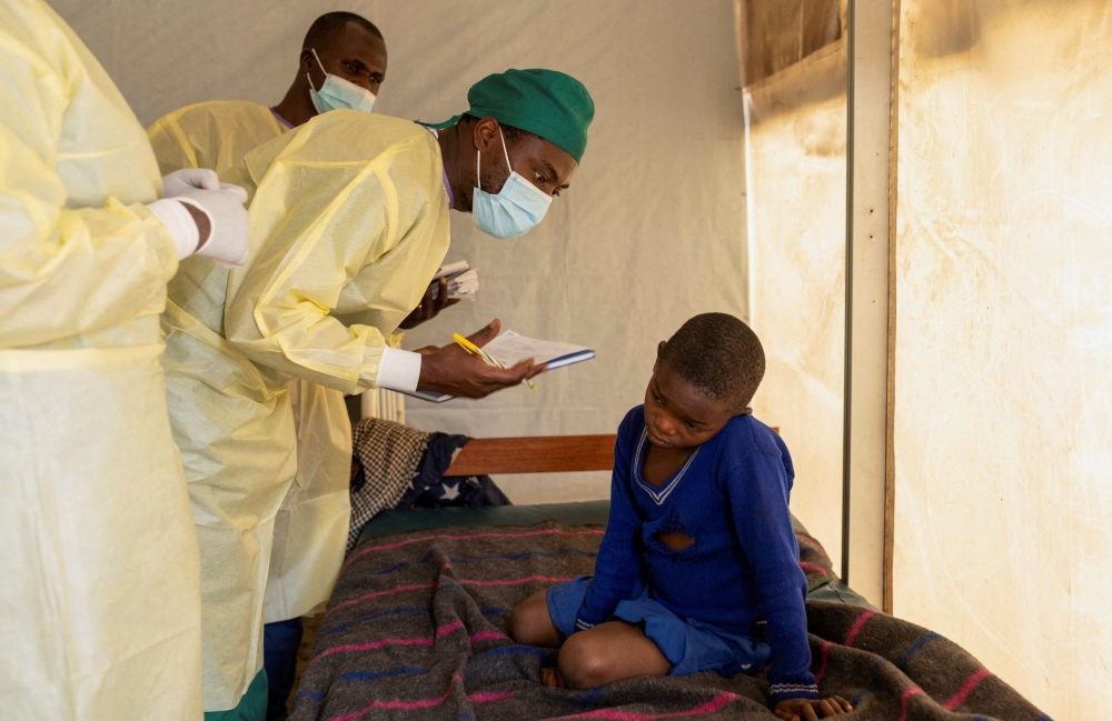 Dr Tresor Wakilongo, verifies the evolution of skin lesions on the ear of Innocent, suffering from Mpox — an infectious disease caused by the monkeypox virus that sparks off a painful rash, enlarged lymph nodes and fever; at the treatment centre in Munigi, following Mpox cases in Nyiragongo territory near Goma, North Kivu province, Democratic Republic of the Congo July 19, 2024. — Reuters pic  