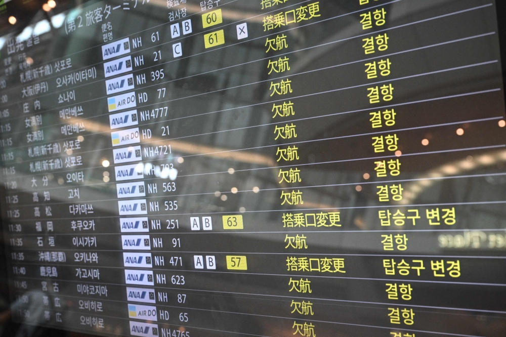 A screen showing the cancelled flight is seen at the departure hall of Tokyo's Haneda Airport on August 16, 2024 as Typhoon Ampil barrels towards Japan's capital. — AFP pic