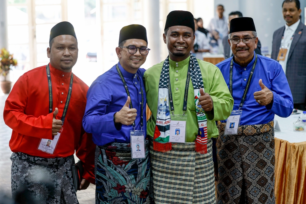 Barisan Nasional’s Mohd Azmawi Fikri Abdul Ghani (second left) and Perikatan Nasional's Mohd Rizwadi Ismail (second right) pose after nomination for the Nenggiri state by-election on August 3, 2024. — Bernama pic