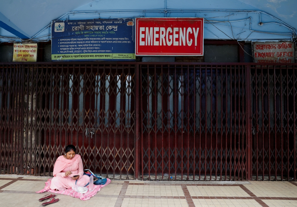 A woman sits outside the medical emergency ward as medics protest against what they say was rape and murder of a trainee doctor, inside the premises of R G Kar Medical College and Hospital in Kolkata August 14, 2024. — Reuters pic  