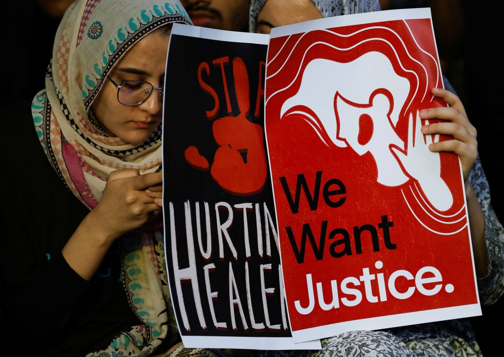 Medical students hold posters as they attend a protest against what they say was rape and murder of a trainee doctor, inside the premises of R G Kar Medical College and Hospital in Kolkata August 13, 2024. — Reuters pic  