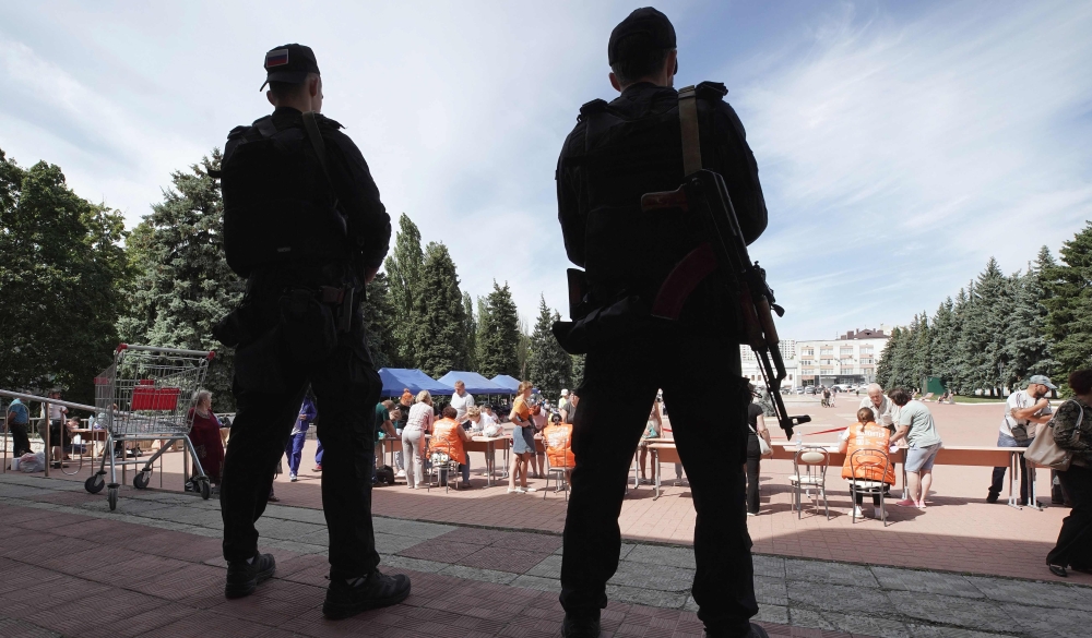 Security guards stand nearby a centre for displaced people and humanitarian aid distribution in Kursk on August 16, 2024, following Ukraine's offensive into Russia's western Kursk region. — AFP pic