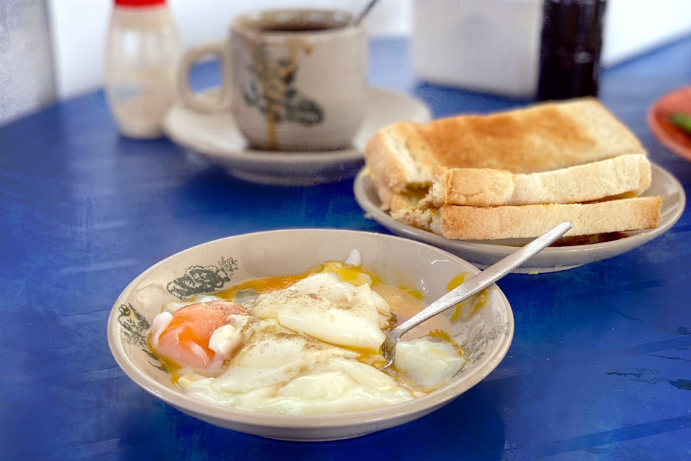 Half boiled eggs and 'roti bakar'. — Picture by CK Lim