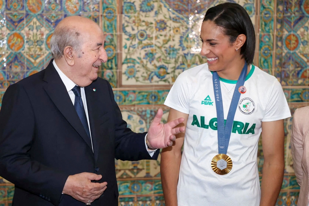 Algerian Olympic boxing gold medallist Imane Khelif is greeted by President Abdelmadjid Tebboune at the Palais d'El Mouradia in Algiers on August 15, 2024. — AFP pic