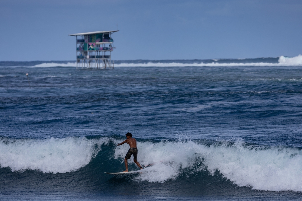 A resident rides a wave near the Paris 2024 Olympics surfing site after the competition was delayed due to poor conditions in Teahupo'o, Tahiti, French Polynesia, July 30, 2024. — Reuters pic