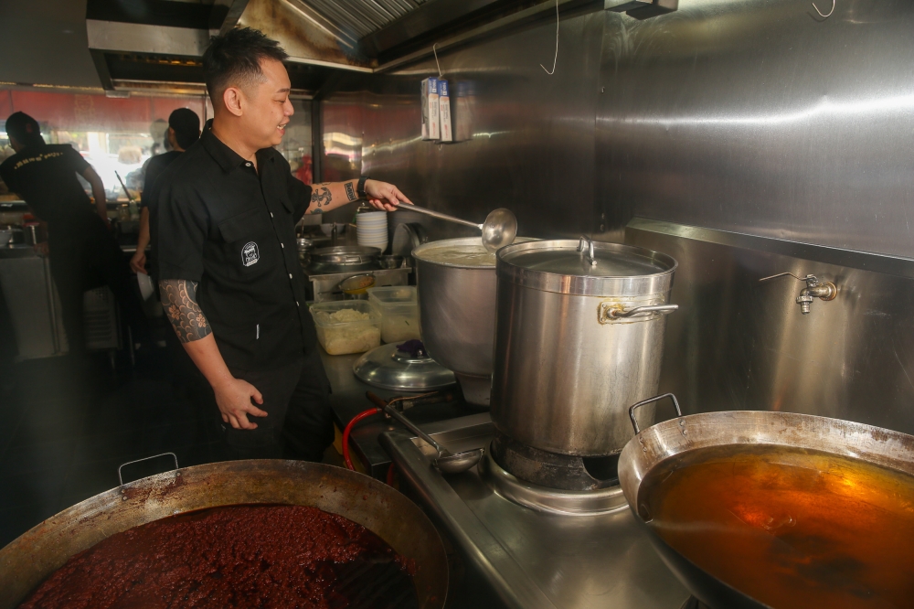 Jun Wang showing how the ingredients for the ‘kai si hor fun’ is prepared like the broth and prawn oil — Picture by Choo Choy May