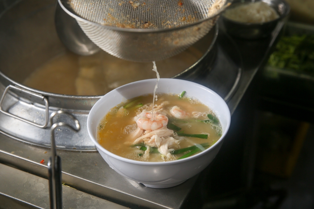 The broth is sieved and added into the bowl with ‘hor fun’, prawns, shredded chicken and spring onions — Picture by Choo Choy May