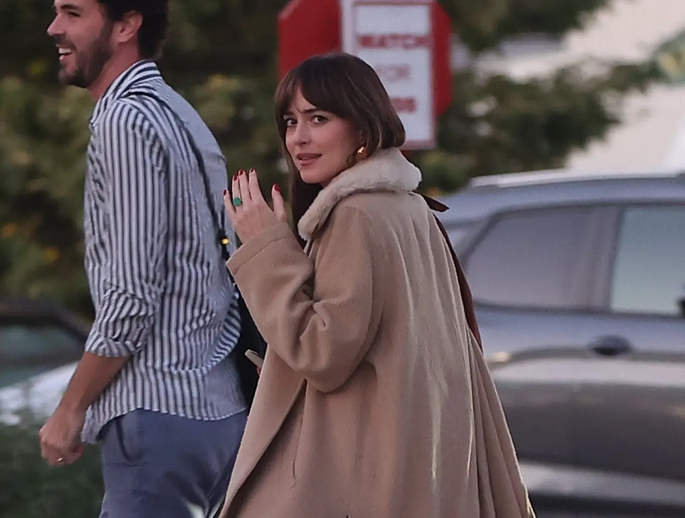 Actress Dakota Johnson flashes finger (and emerald engagement ring) at paparazzi, shutting down rumours of split with Coldplay's Chris Martin