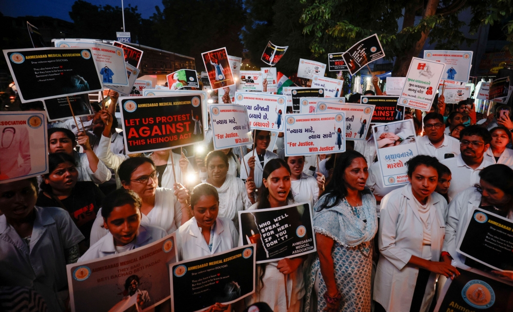 Doctors hold posters and shout slogans during a protest march demanding justice following the rape and murder of a trainee medic at a hospital in Kolkata, in Ahmedabad August 17, 2024. — AFP pic