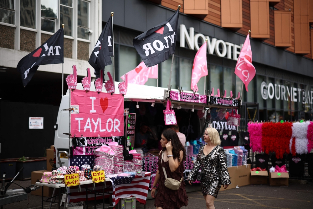 Fans of US mega-star Taylor Swift, so-called Swifties, pass merchandise stalls outside Wembley Stadium in London on August 15, 2024, ahead of the first of five concerts she is playing at the stadium. — AFP pic