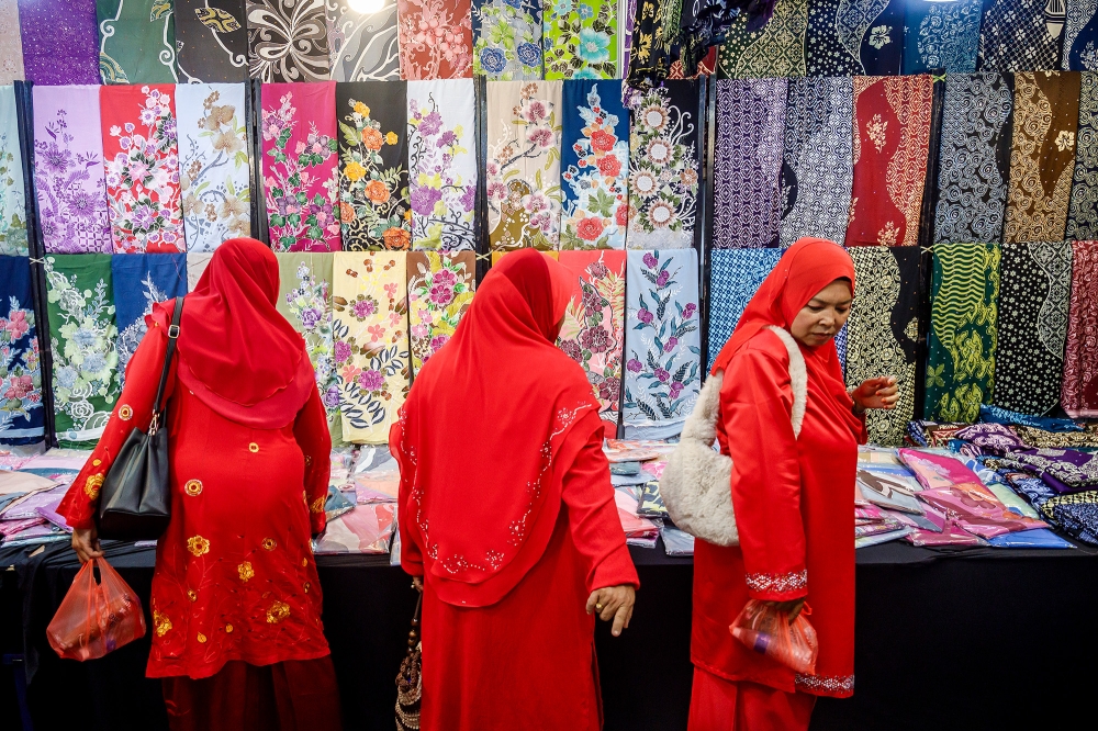 Delegates look at batik offerings at the 2024 Umno General Assembly at the World Trade Centre Kuala Lumpur August 23, 2024. — Picture by Firdaus Latif