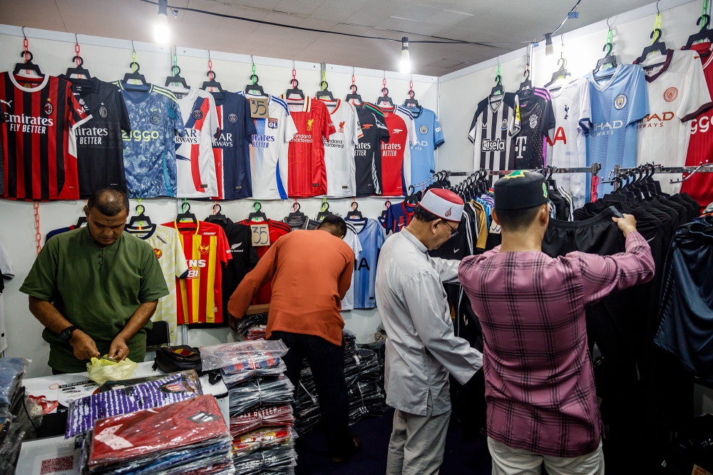 Ahmed Hamed, vendedor de réplicas de camisetas, está pasando por momentos difíciles con los cazadores de gangas que le ofrecen precios bajos. — Foto de Ferdous Latif