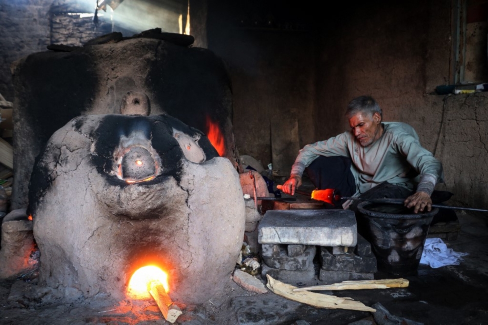 In this photograph taken on August 11, 2024, Ghulam Sakhi Saifi, an Afghan glassblower, crafts a glassware at his traditional workshop in Afghanistan’s western city of Herat. — AFP pic