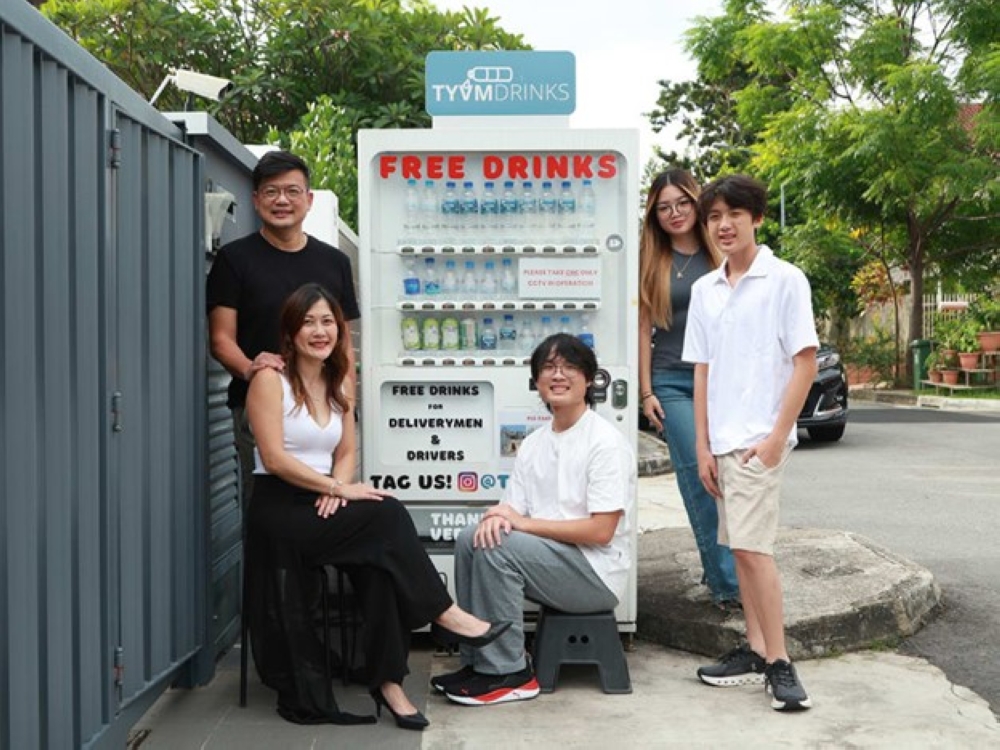 (Left to right) Dr Eric Chiam and Dr Lisa Chen with their children Ethan, Sophia and Andre. The family set up a vending machine dispensing free drinks for delivery riders outside their home in Siglap.