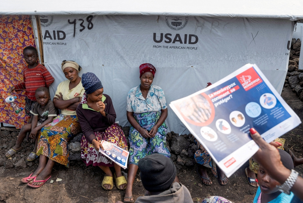 Internally displaced women listen to Nathalie Kipenzi, a hygiene promoter, during an awareness campaign for Mpox, an infectious disease caused by the Mpox virus that causes a painful rash, enlarged lymph nodes and fever, at the Muja camp for the internally displaced in Nyiragongo territory, near Goma in North Kivu province of the Democratic Republic of Congo August 19, 2024. — Reuters pic  