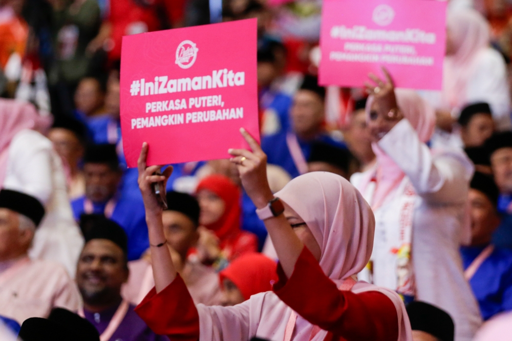 Young Umno members hold up placards reading “#IniZamanKita” during the party’s general assembly at the World Trade Centre in Kuala Lumpur on August 24, 2024. — Picture by Raymond Manuel