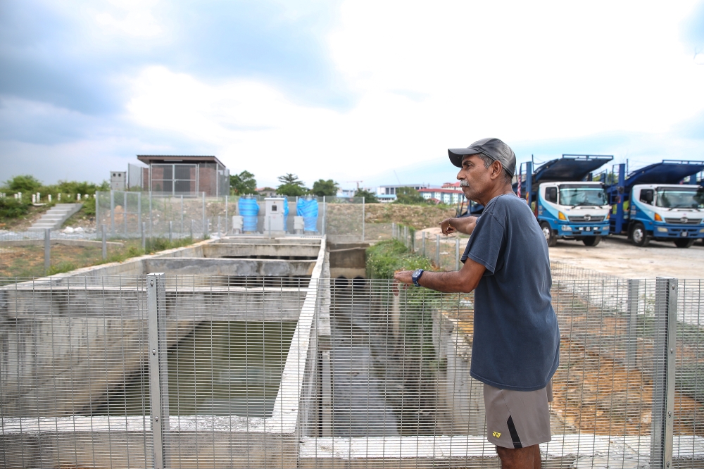 Taman Sri Muda Zone D Residents Association chairman Andrew De Silva pointing to the water pumps that has yet to be operational. — Picture by Yusof Mat Isa