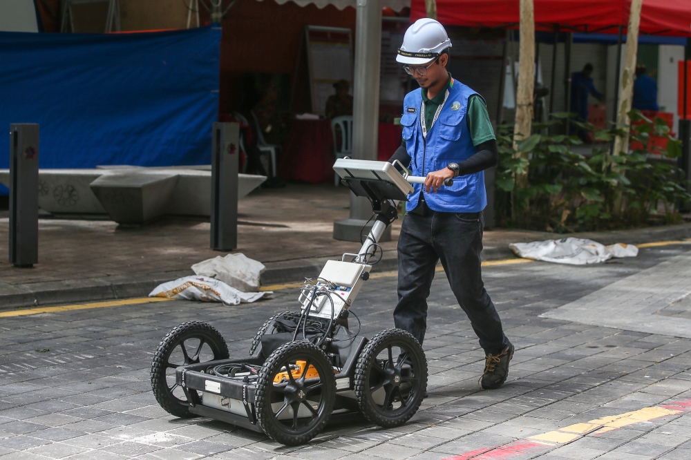 A representative from the Department of Mineral and Geoscience Malaysia is seen wheeling a ground penetrating radar (GPR) device at the Jalan Masjid India in Kuala Lumpur August 28, 2024. — Picture by Yusof Mat Isa