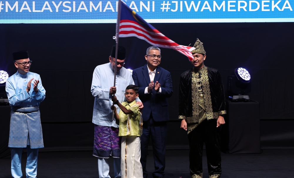 Prime Minister Datuk Seri Anwar Ibrahim hands over the Jalur Gemilang to Sai Rakesh Vijayan, 6, from Tabika Perpaduan Sri Sungai Pelek Sepang during the 2024 National Day Address at the Putrajaya International Convention Centre (PICC), August 30, 2024. — Bernama pic 