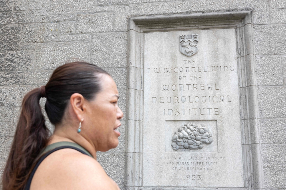 Mohawk Mother Kwetiio passes in in front of the dedication plaque of the McConnell Wing of the Montreal Neurological Institute-Hospital on July 17, 2024, in Montreal. — AFP pic