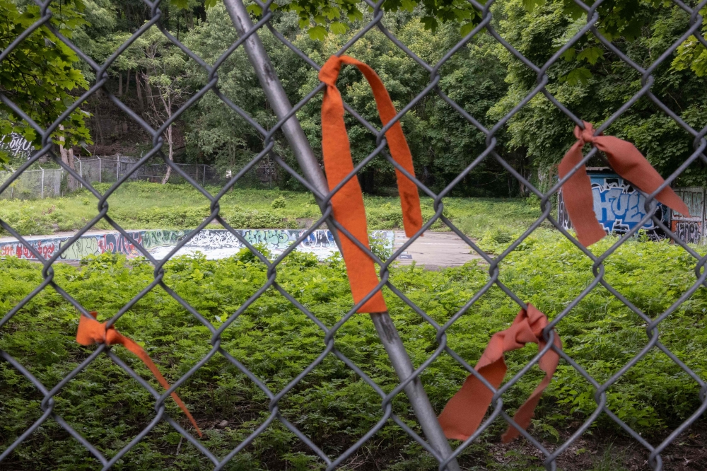 Orange ribbons representing missing indigenous children hang from the fence that runs alongside the Henry William Morgan Pool, on July 17, 2024, in Montreal. — AFP pic