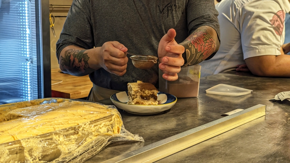 A full portion of tiramisu is dusted with cocoa powder after being plated. — Picture by Ethan Lau