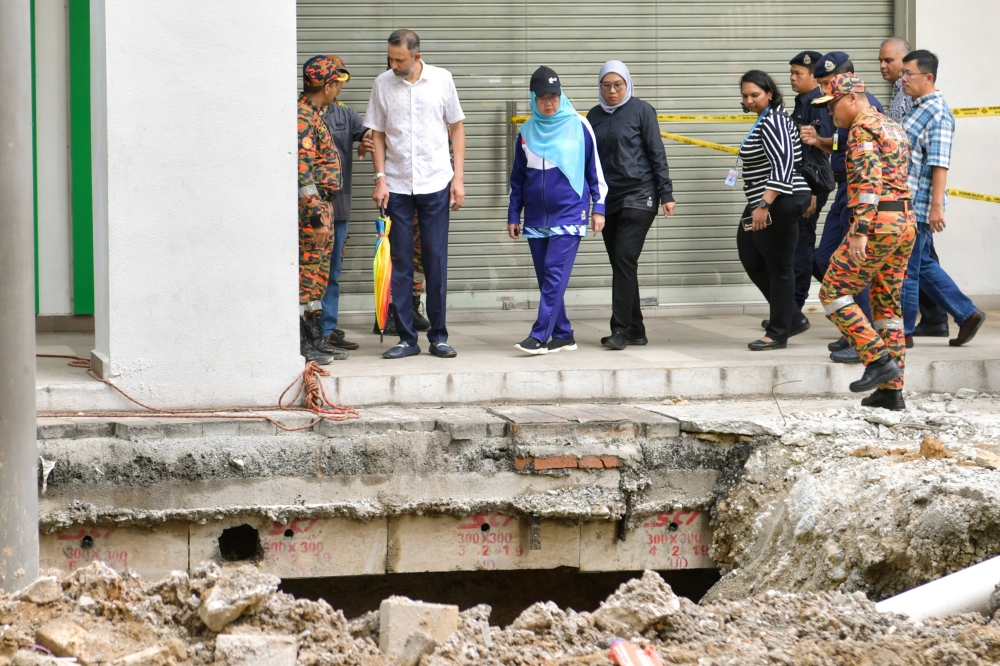 Minister in the Prime Minister’s Department (Federal Territories) Dr Zaliha Mustafa (centre) looks at the area where an Indian tourist fell into a sinkhole along Jalan Masjid India in Kuala Lumpur, August 24, 2024. — Bernama pic