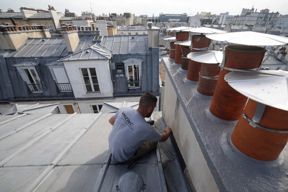 File picture of Romain Florentin, a roofer and zinc worker, working on the roof of a building in Paris, on July 31, 2024. The French culture ministry has chosen the zinc roofers as the country’s entry for the Unesco list of Intangible Cultural Heritage to be decided at the UN body’s session in Paraguayan capital Asuncion in December. — AFP pic 