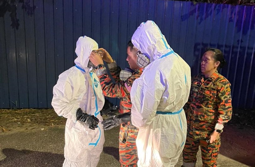 Fire and Rescue personnel put on hazmat suits after chemical odour pollution was detected around Taman Mount Austin, Taman Daya and Taman Istimewa in Johor Baru. — Picture courtesy of Johor Fire and Rescue Dept