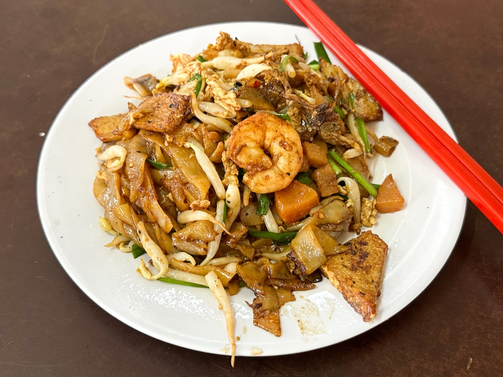 The ‘char kway teow’ with flat rice noodles are well charred and topped with naughty crunchy fried lard. — Picture by Lee Khang Yi