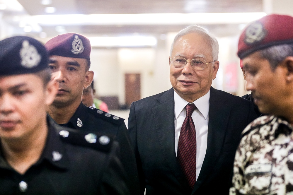 A file photograph shows police guarding former prime minister Datuk Seri Najib Razak at the Kuala Lumpur Court Complex. — Picture by Sayuti Zainudin