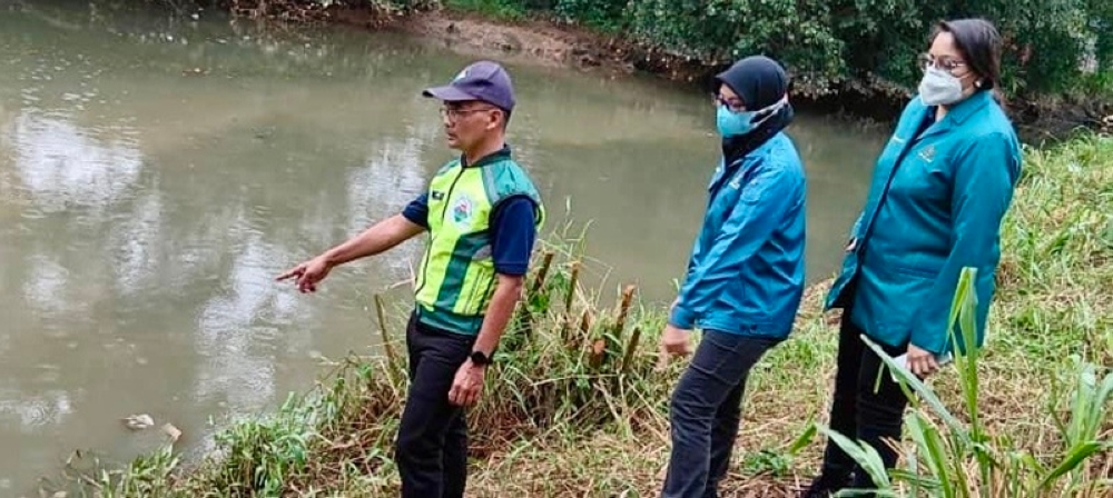 Johor Department of Environment (DoE) senior deputy director Mohd Rashdan Topa (left) and several department personnel at a location  where water and air samples were taken earlier along Sungai Pandan in Kampung Melayu Pandan, near Johor Baru September 4, 2024. — Picture by Ben Tan