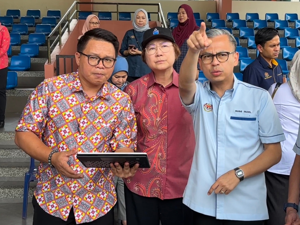 Federal Communications Minister Fahmi Fadzil with state Tourism, Culture and Environment Minister Datuk Christina Liew (centre) looking at plans for Malaysia Day at Padang Merdeka, Kota Kinabalu, September 5, 2024. — Picture by Julia Chan 