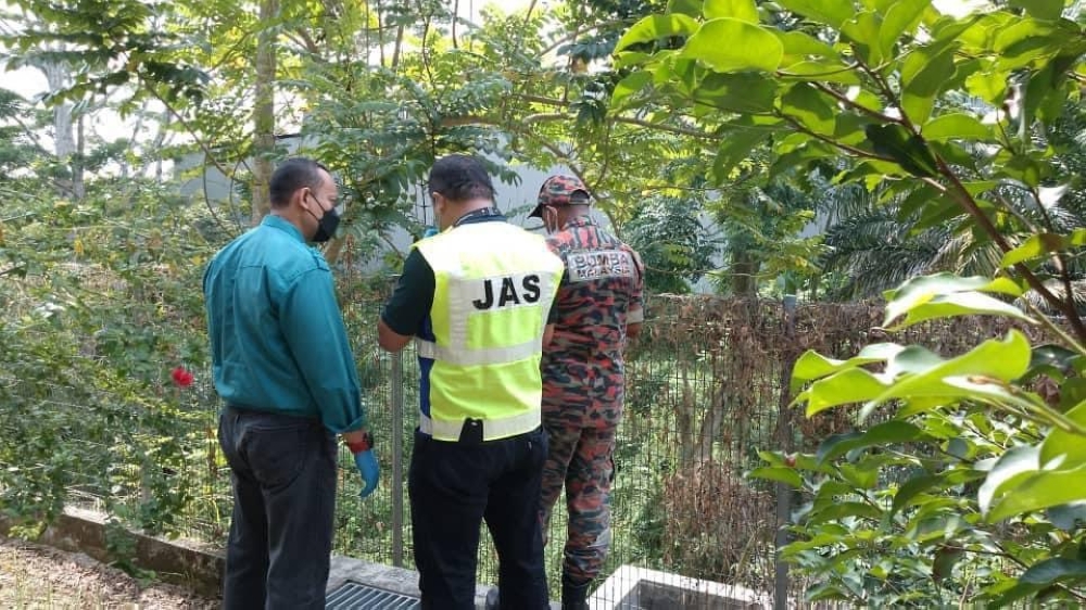 Johor Department of Environment (DoE) and the State Fire and Rescue Department personnel collecting soil and water samples along Sungai Pandan that runs through the Taman Desa Tropika industrial area in Johor Jaya. — Picture courtesy of Ling Tian Soon