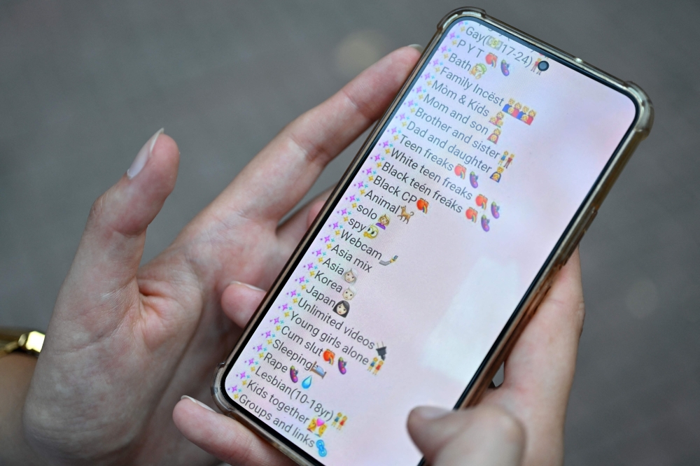 Legal expert Jelena Drndarski shows screenshots of several Telegram groups on her mobile phone in Belgrade, Serbia on September 3, 2024. — AFP pic