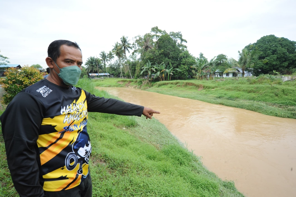 A resident of Kampung Maju Jaya in Johor Baru points to Sungai Tebrau following the odour pollution that occurred yesterday.