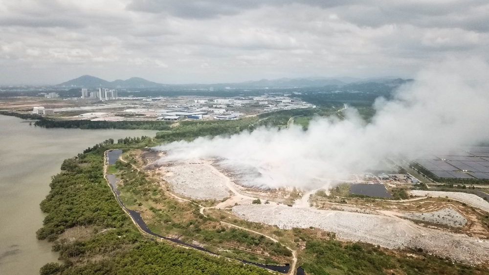 An aerial view shows thick smoke from underground burning on the Pulau Burung Landfill in Nibong Tebal, Penang on January 17, 2022. Researchers found that the largest increases in methane gases come from China and South-east Asia and have been primarily linked to coal extraction, oil and gas production and landfills. — Picture by Sayuti Zainudin