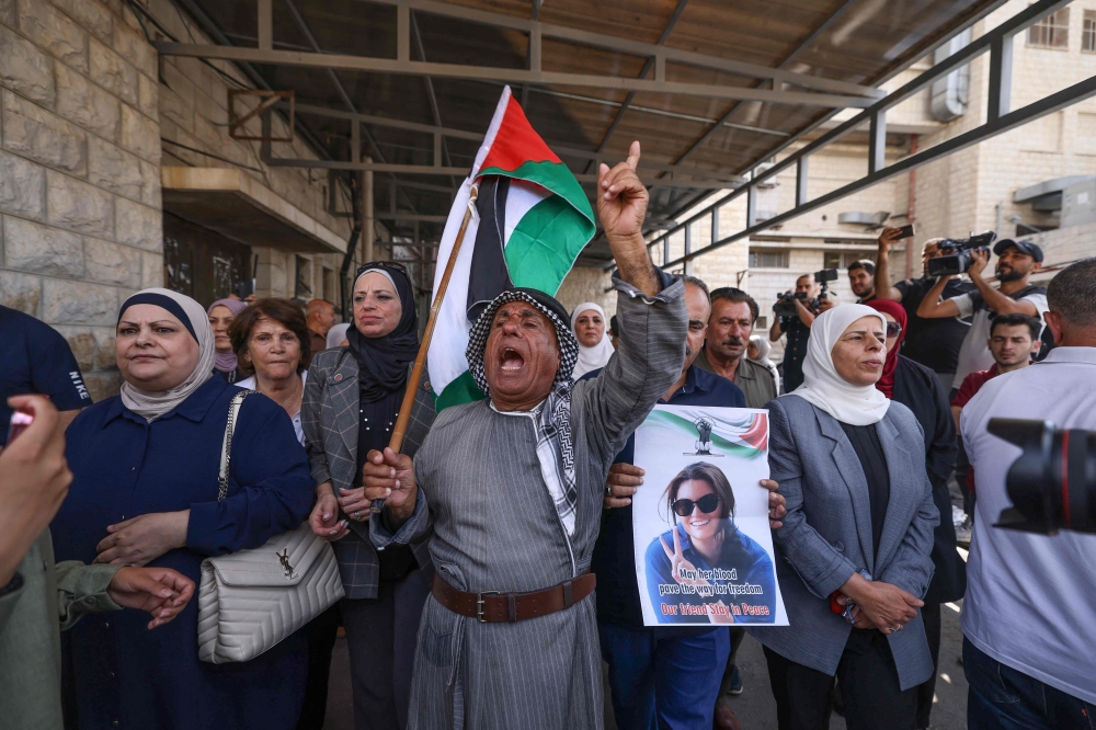 Palestinians and international activists lift portraits of slain Turkish-American activist Aysenur Ezgi Eygi as they arrive for her final farewell at the Rafidia hospital morgue in Nablus in the occupied West Bank on September 8, 2024. — AFP pic