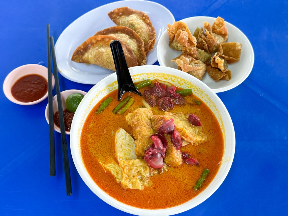 Curry mee is perfect for rainy days with cockles, smooth poached chicken, long beans and pig skin. — Picture by Lee Khang Yi