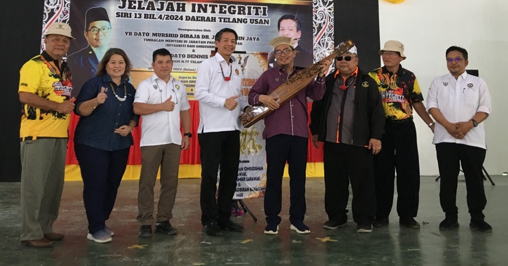 Deputy Minister in the Premier’s Department (Integrity and Ombudsman) Datuk Juanda Jaya (4th right) receives a sape as a token of appreciation from Dennis, on his right, as (from 2nd left) Elizabeth, Ezra and others look on. — The Borneo Post 