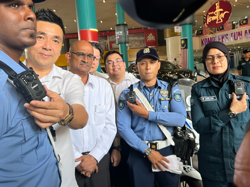 Penang state exco H’ng Mooi Lye (2nd left) and Penang Island City Council Mayor Datuk A. Rajendran (3rd left) pose with the MBPP officers wearing body cameras. — Picture by Opalyn Mok