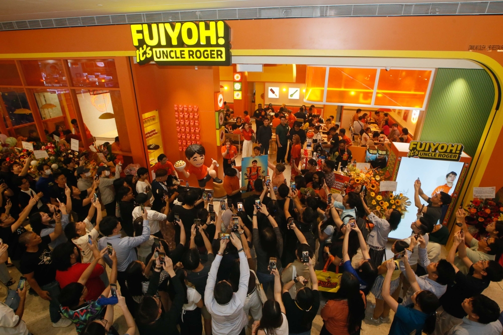 A large crowd gathers at the grand opening of Uncle Roger’s first restaurant, ‘FUIYOH! It’s Uncle Roger,’ as fans take pictures and celebrate the event at Pavilion Kuala Lumpur, September 11, 2024. —Picture by Raymond Manuel