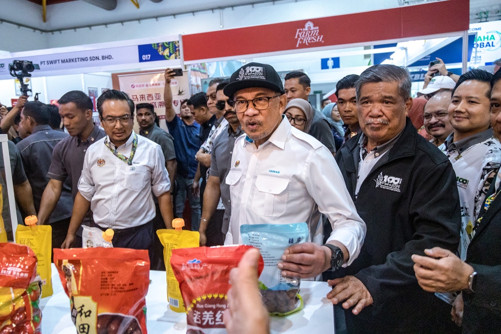 Prime Minister Datuk Seri Anwar Ibrahim and Agriculture (centre) and Food Security Minister Datuk Seri Mohamad Sabu (front, right) visit a booth after the launch of the Malaysian Agriculture, Horticulture and Agro-tourism Exhibition (Maha) 2024 at the Malaysia Agro Exposition Park Serdang (MAEPS) in Serdang September 11, 2024. — Picture by Firdaus Latif