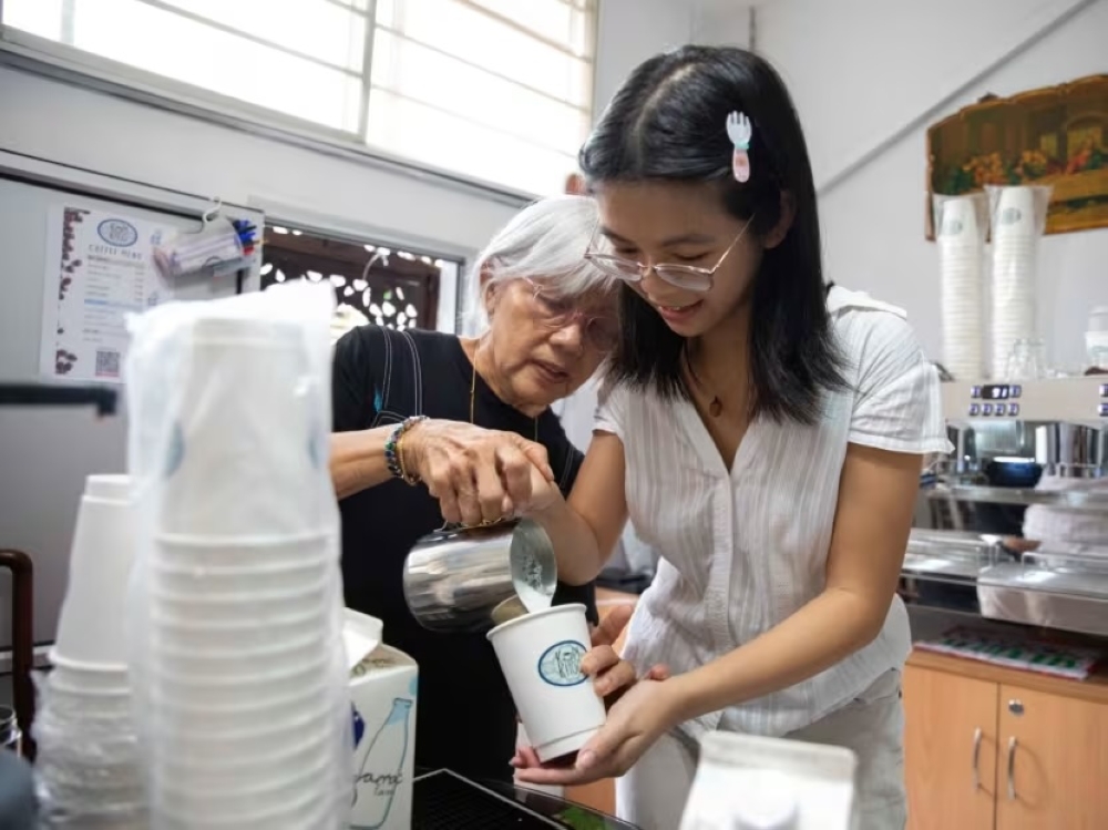 Paulin Khoo showing TODAY journalist Nikki Yeo how to make a latte in her kitchen on September 10, 2024. — TODAY pic