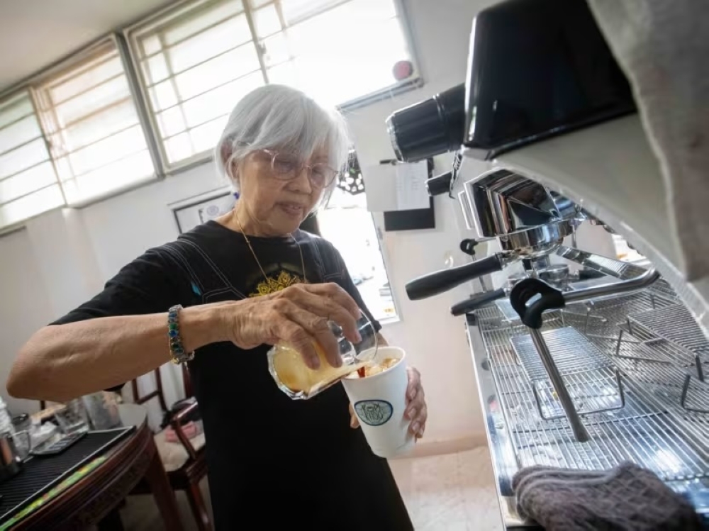 Paulin Khoo makes coffee in her kitchen using an espresso machine bought by her son for Kopikhoo. — TODAY pic