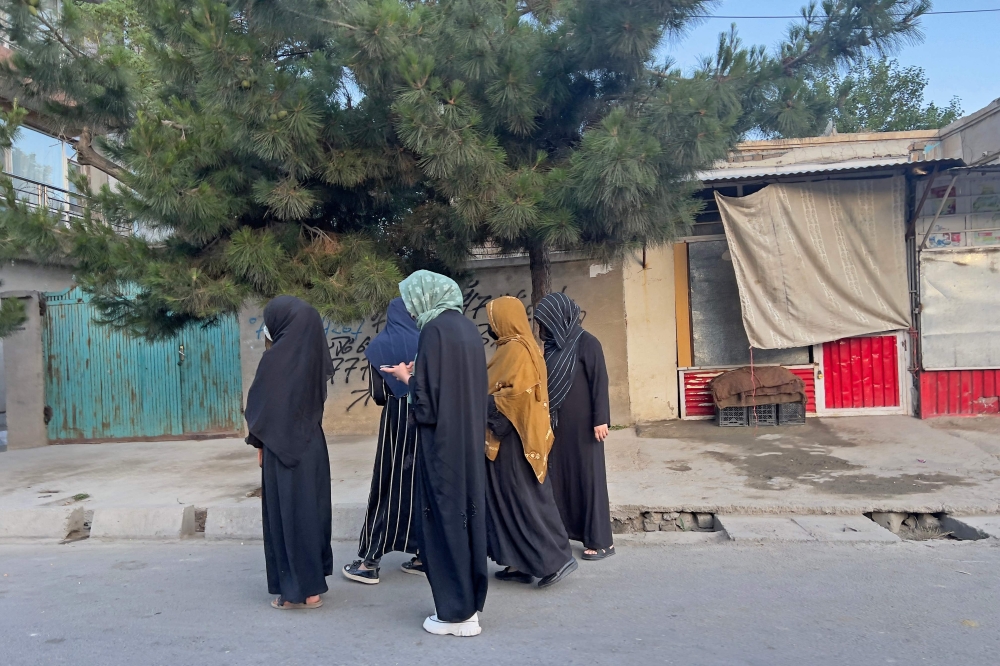 In this photograph taken on June 26, 2024, Afghan women walk along a road during early morning in Kabul. — AFP pic 