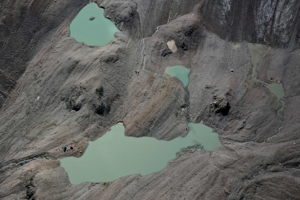 This aerial photograph taken on July 8, 2024 shows lakes of melted water in the Tian Shan mountain range. The effects of a warming planet have been particularly visible in Central Asia, which has seen a wave of extreme weather disasters. — AFP pic