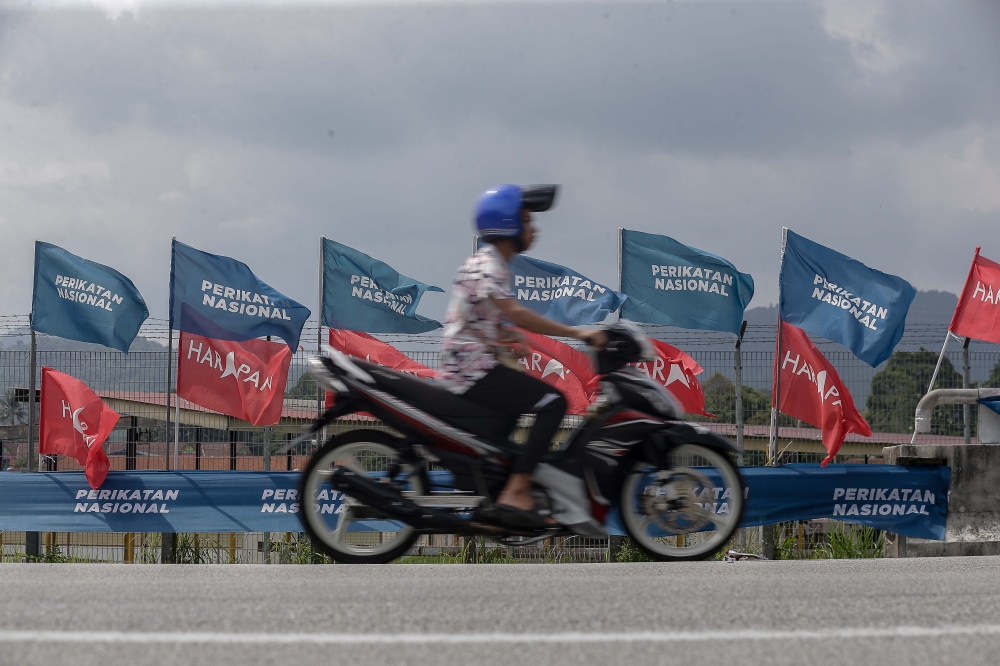 A motorist drives past party flags in Kuala Kubu Baru May 2, 2024. — Picture by Sayuti Zainudin