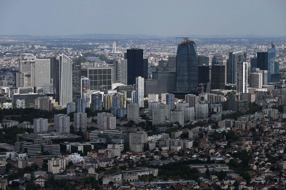 This aerial view shows the La Defense business district and the Aillaud Towers of the Pablo Picasso area of Nanterre, north-west of Paris July 11, 2023. — AFP pic