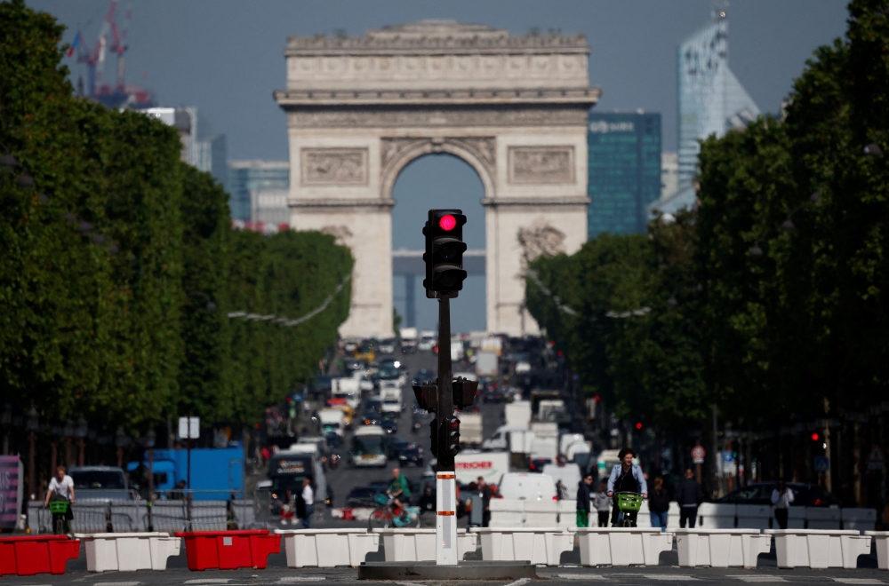 File photo of traffic light shining red on the Champs-Elysees avenue with the Arc de Triomphe in the background in Paris June 13, 2024. — Reuters pic